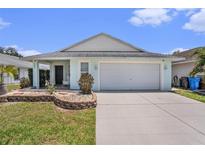 Charming single-story home features a well-manicured lawn, a two-car garage, and a welcoming covered front porch at 1106 Humble Haven St, Ruskin, FL 33570