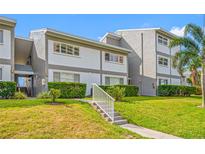 Low angle view of the property's exterior featuring lush landscaping and manicured lawn at 1351 Gulf Blvd # 209, Clearwater Beach, FL 33767