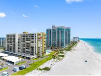 Aerial view of beachfront condos with pools, manicured lawns, and ample parking at 1480 Gulf Blvd # 1004, Clearwater Beach, FL 33767