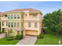 Elegant townhome featuring a paver driveway, attached garage, and beautiful landscaping at 1532 Citrine Trl, Tarpon Springs, FL 34689
