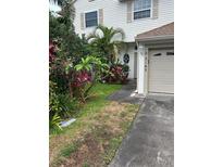 Two-story home exterior with a well manicured front yard and attached garage at 3145 Meta Ct, Largo, FL 33771