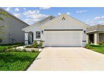 Charming single-Gathering home featuring a two-car garage, manicured lawn, and neutral color scheme at 36673 Spanish Rose Dr, Dade City, FL 33525
