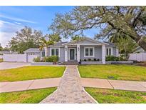 Charming home featuring a manicured lawn, covered entry, and stone walkway at 493 Lucerne Ave, Tampa, FL 33606