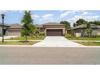 Beautiful single story home with lush green landscaping and a large driveway at 5518 Blue Azure Dr, Wimauma, FL 33598