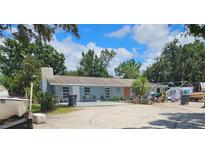Charming single-story home with a neutral exterior, set against a backdrop of lush trees and a bright, cloudy sky at 1114 27Th Se St # A, Ruskin, FL 33570