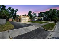 Charming home featuring a well-maintained lawn, large windows, and a driveway at sunset at 2018 21St S St, St Petersburg, FL 33712