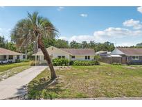 Charming single-story home featuring a palm tree in the front yard and a cozy covered porch at 2626 Cheryle Ln, Sarasota, FL 34237