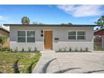 Modern single-story home featuring a minimalist design, stylish wood door, and fresh landscaping at 3151 6Th S Ave, St Petersburg, FL 33712