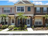 Charming townhome featuring colorful shutters, tropical landscaping, and a welcoming entrance at 6231 Bayside Key Dr, Tampa, FL 33615