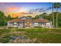 Beautiful single-story home featuring mature landscaping and a welcoming facade at sunset at 7206 River Country Dr, Weeki Wachee, FL 34607