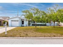 Charming single-story home with a well-maintained lawn, mature trees, and a welcoming entrance at 7777 117Th St, Seminole, FL 33772
