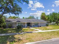 Charming single story brick home featuring a well maintained lawn and sidewalk entrance at 10408 Butia Pl, Tampa, FL 33618