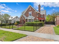 Charming brick two-story home featuring a manicured lawn and walkway at 126 14Th Ne Ave, St Petersburg, FL 33701