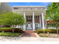 Elegant red brick home featuring a covered entryway supported by grand white pillars and beautiful landscaping at 219 4Th N Ave # 201, St Petersburg, FL 33701