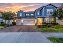 Beautiful two-story home with a three-car garage and attractive landscaping at sunset at 2641 Whittler Br, Odessa, FL 33556