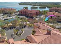 Stunning aerial view of a condo complex with a red tile roof, parking, and waterfront access at 2722 Via Tivoli # 430A, Clearwater, FL 33764
