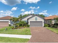 Charming single-story home featuring a brick driveway, manicured lawn, and lush landscaping at 3166 Francoa Dr, Odessa, FL 33556