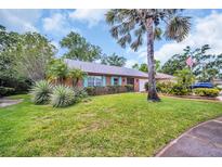Charming single-story brick home with well-manicured lawn and tropical landscaping at 3224 Hilary Cir, Palm Harbor, FL 34684