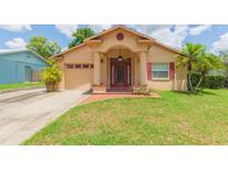 Charming single-story home with a red door and columns, plus a well-manicured front yard at 39055 9Th Ave, Zephyrhills, FL 33542
