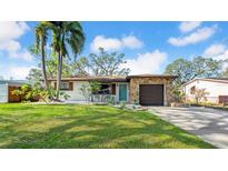Charming single-story home featuring a stone facade, attached garage, manicured lawn, and mature landscaping at 4642 29Th N Ave, St Petersburg, FL 33713