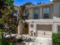 Charming two-story townhouse featuring an attached garage and a welcoming front entrance with decorative wreath at 4732 Ashburn Pond Way, Tampa, FL 33610