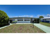 Charming single-story home with a covered carport and awning-shaded windows, surrounded by a well-maintained yard at 5318 Mary St, Zephyrhills, FL 33542
