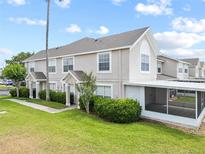 Inviting townhome showcasing manicured landscaping and a screened-in patio at 659 Kensington Lake Cir, Brandon, FL 33511