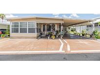 Charming single-story home with a covered carport and decorated porch, perfect for relaxing outdoors at 7053 El Conquistador St, Zephyrhills, FL 33541