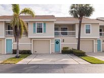 Inviting condo exterior with light beige siding, blue doors, and palm trees at 12321 Sun Vista W Ct # 52, Treasure Island, FL 33706