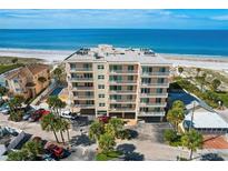 Beachfront condo building with balconies overlooking the ocean, parking and neighboring property at 13440 Gulf Blvd # 501, Madeira Beach, FL 33708