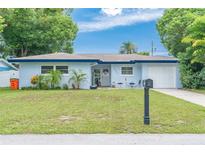 Charming one-story home with well-manicured lawn, inviting front door, and attached one car garage at 1503 4Th St Sw, Largo, FL 33770