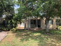 Charming single-story home featuring mature trees, a covered porch, and a well-maintained lawn at 1508 S Clark Ave, Tampa, FL 33629