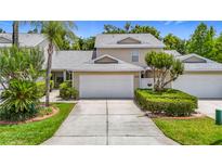 Charming two-story townhouse with a well-manicured lawn and attached two-car garage at 1628 Lullwater Ln, Lutz, FL 33549