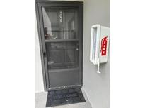 View of the apartment's front door with welcome mat and fire extinguisher box at 2650 Countryside Blvd # C106, Clearwater, FL 33761