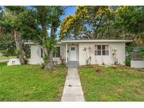 Quaint single-story home with lush landscaping, mature trees, and a welcoming entrance path on a green lawn at 4600 Chancellor Ne St, St Petersburg, FL 33703