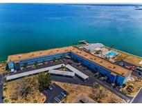 Beautiful aerial view of a waterfront condo community featuring a pool, clubhouse, and covered parking at 5 Gateshead Dr # 308, Dunedin, FL 34698