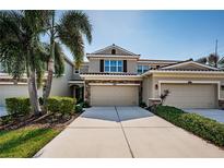 Charming townhome featuring a well-manicured lawn, stone accents, and a spacious two-car garage at 5225 5Th N Way, St Petersburg, FL 33703