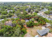 Aerial view of property with tree coverage, showing the house's lot outlined in red at 5232 72Nd N Way, St Petersburg, FL 33709