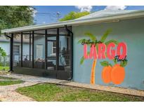 Charming Florida home featuring a screened-in porch and a vibrant 'Greetings from Largo' mural at 616 11Th Nw St, Largo, FL 33770