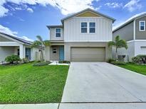 Charming two-story home with well-maintained lawn, a two-car garage, and front yard landscaping at 7554 Wallflower Trl, Wesley Chapel, FL 33545