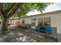 Inviting front porch with blue chairs and well-maintained landscaping at 11104 Taft Dr, Port Richey, FL 34668