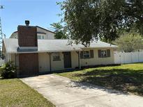 Charming single story home with a brick chimney, neutral paint, and long driveway at 13601 Audrey Ln, Largo, FL 33771