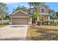 Charming home featuring a two-car garage, well-manicured lawn and mature landscaping at 1605 Acorn Seed Ct, Valrico, FL 33594