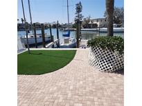 Waterfront property featuring a boat dock with lush landscaping and boat mooring at 319 Boca Ciega Dr, Madeira Beach, FL 33708
