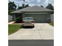 Charming one-story home with a gray roof, lush lawn and a spacious two-car garage at 3505 Gloria Ave, Plant City, FL 33563
