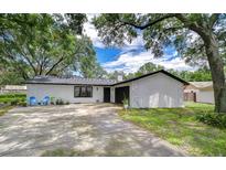 Charming single-story home featuring a freshly painted exterior, black trim, and a spacious driveway at 4911 Country Aire Ln, Tampa, FL 33624