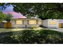 Charming home with landscaped front yard shaded by a mature tree; solar panels installed at 5010 8Th N Ave, St Petersburg, FL 33710