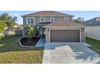 Charming two-story home with a well-manicured lawn, two-car garage and mature trees in a Gathering-friendly neighborhood at 5236 Treig Ln, Wesley Chapel, FL 33545