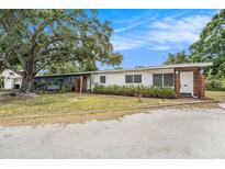 Charming single-story home featuring a brick entryway and lush landscaping, under a blue sky at 5250 12Th N St, St Petersburg, FL 33703