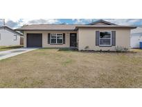 Charming single-story home with tan siding, brown shutters, and a well-maintained lawn at 717 Fairmont Dr, Brandon, FL 33511